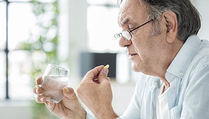 elderly man taking medication