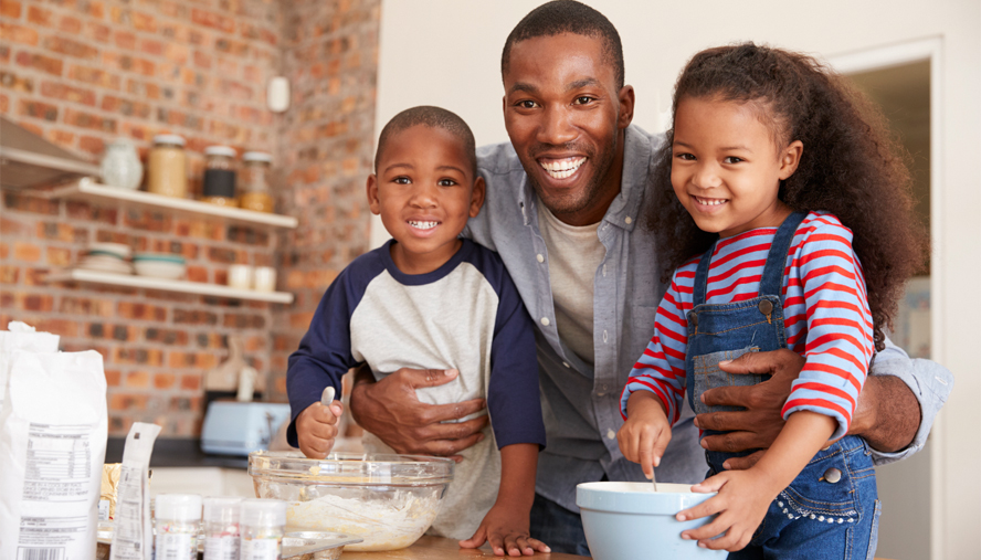 Two children baking with their father