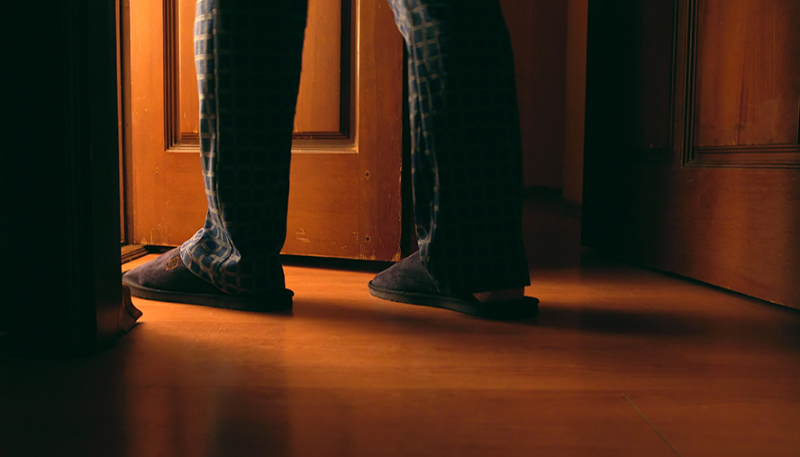 Person standing at doorway of bedroom