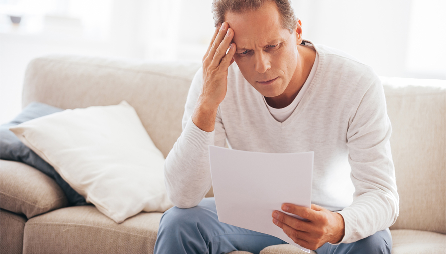 Man reading stressing paper