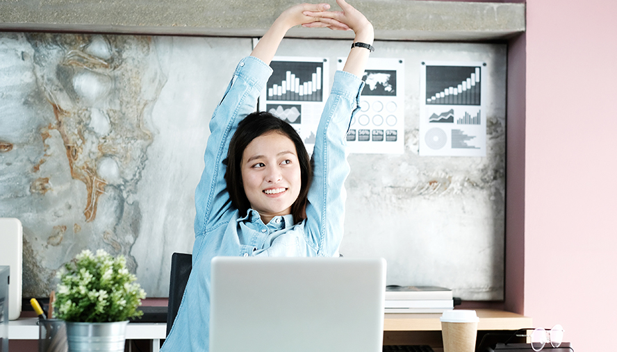 Woman stretching in front of her computer