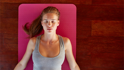 Woman lying on yoga mat