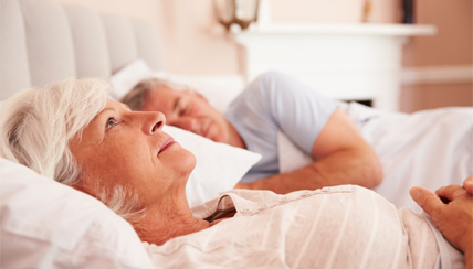 senior couple laying in bed