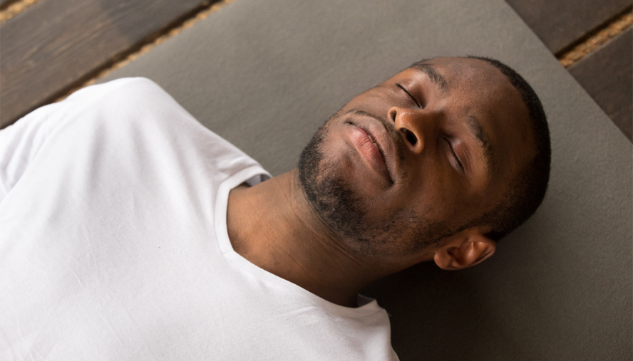 Man lying peacefully on yoga mat