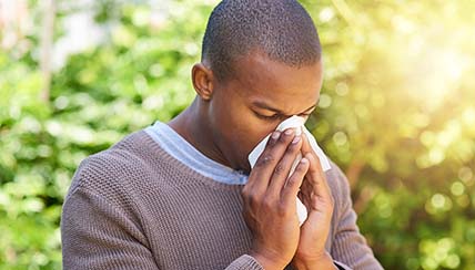 man blowing his nose