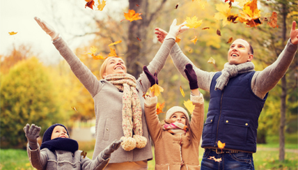 family throwing leaves in the fall