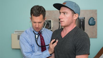 Physician taking heart beat