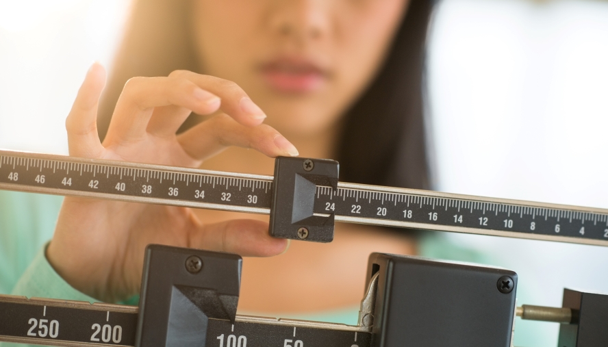 Woman checking her weight on a scale