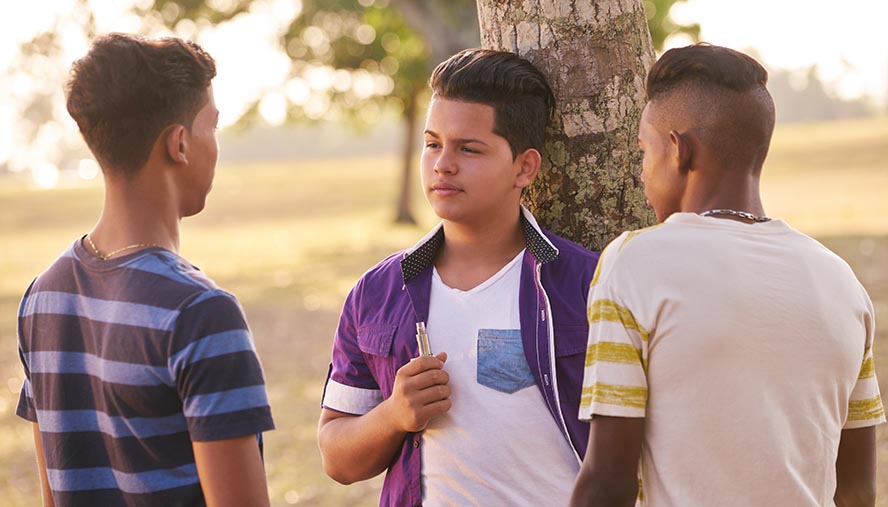 group of teens using vapes